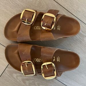 Brown leather Birkenstocks with gold buckle
